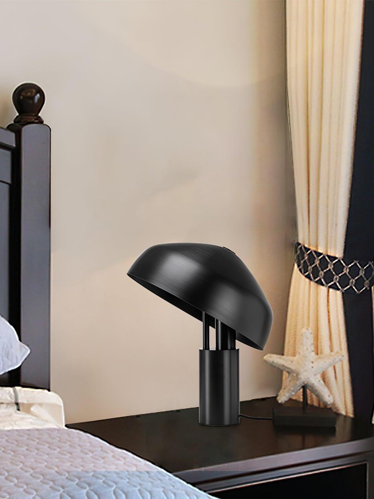 Black tilted dome lamp beside bed