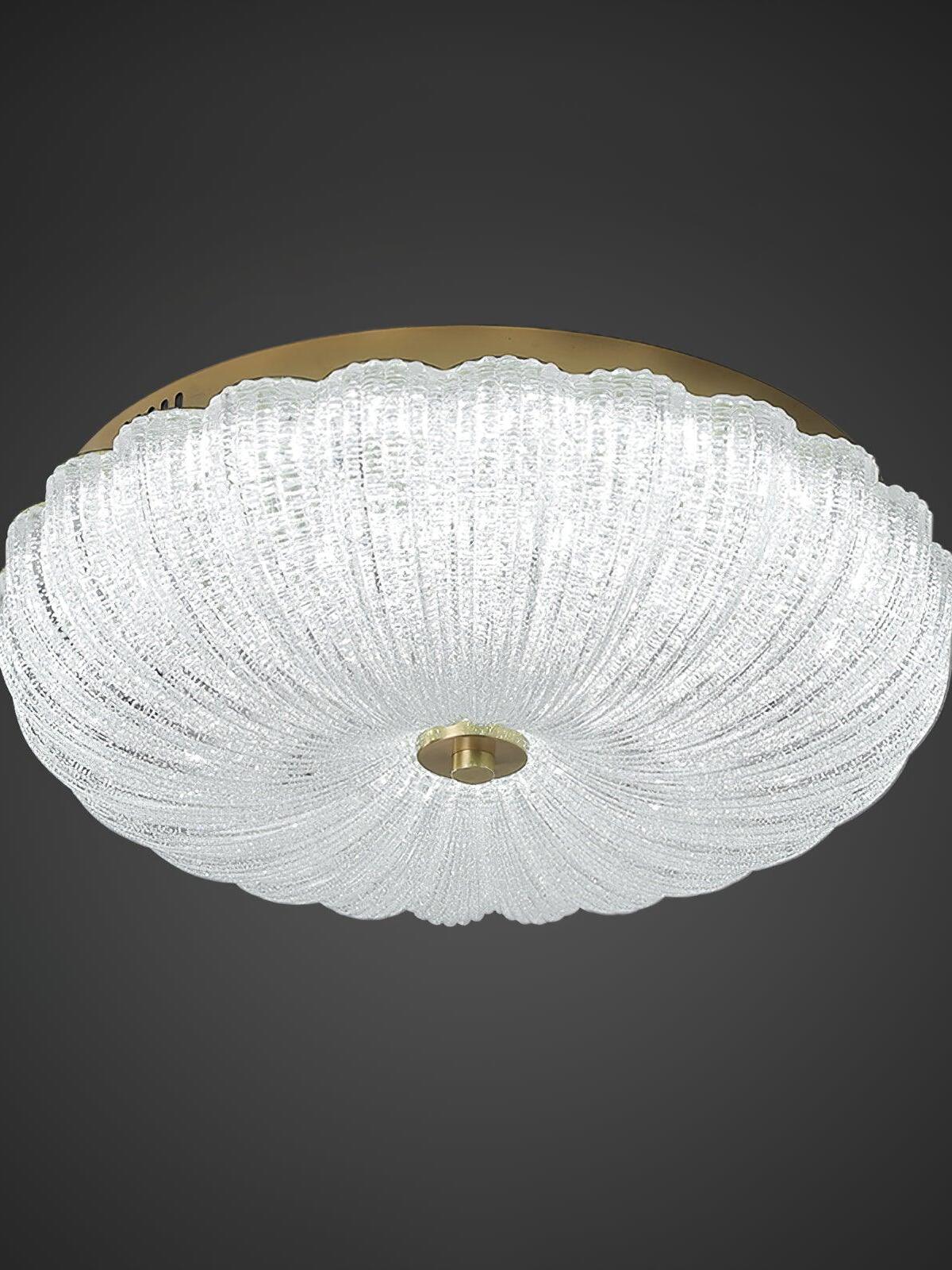 Fluted glass ceiling light with a cooler white glow, gold-tone rim and central round finial