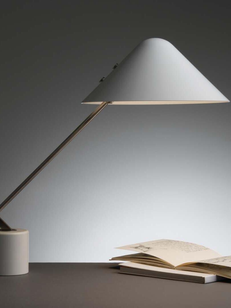 Dark-room view of an angled shade above an open book on a desk