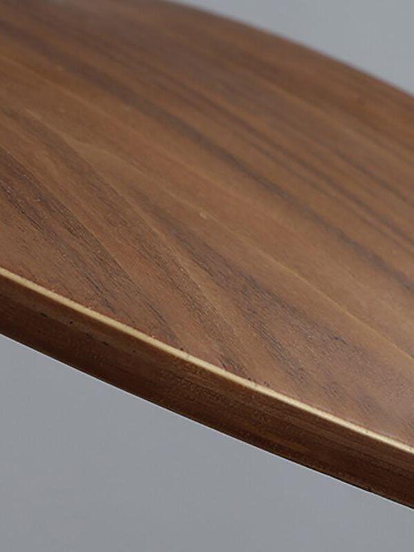 Detail of the curved wood-grain surface and edge against a pale background