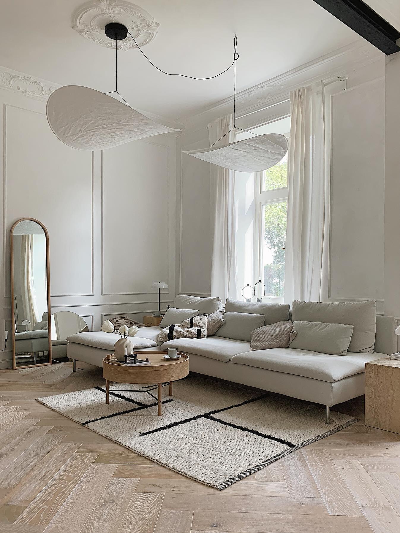 Two white sweeping shades in a bright lounge