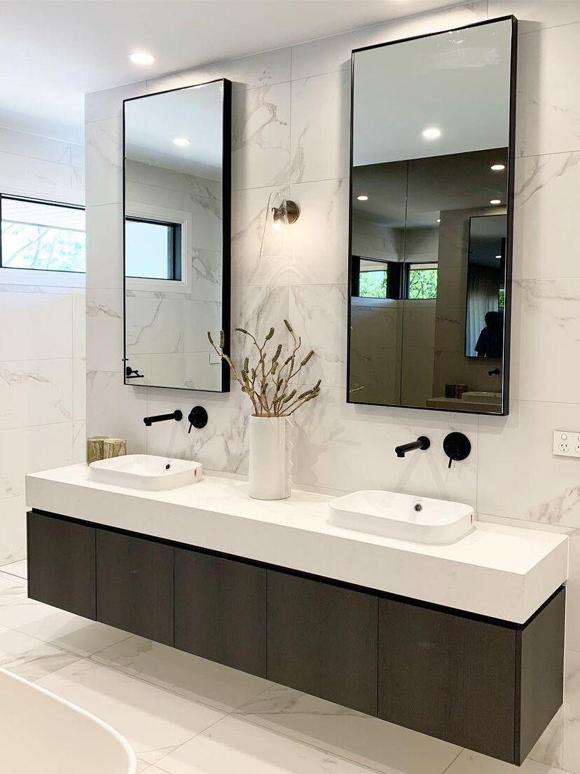 Wall lights beside mirrors in a bathroom scene