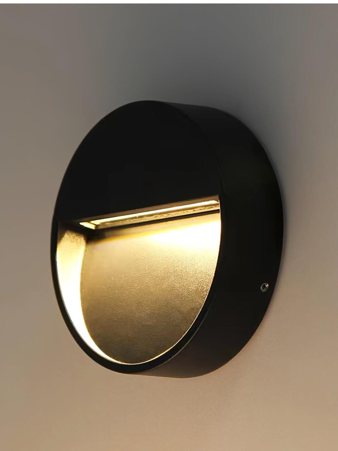 Round black wall lamp in angled side view