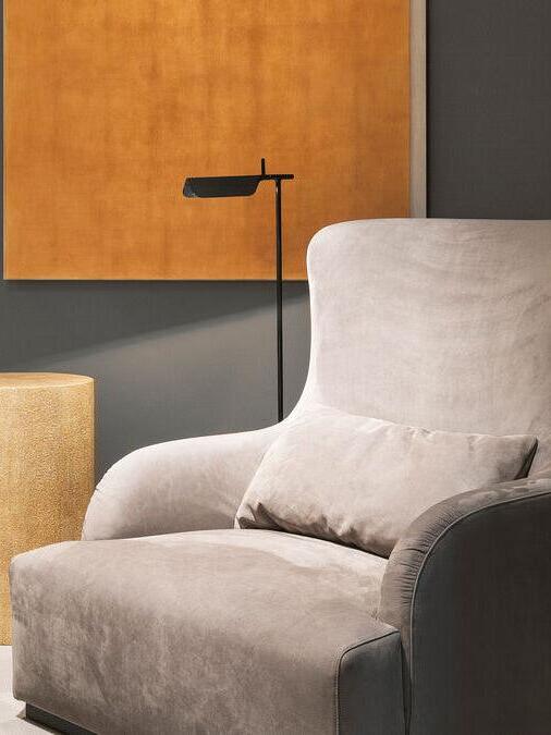 Black floor lamp behind a light-coloured armchair
