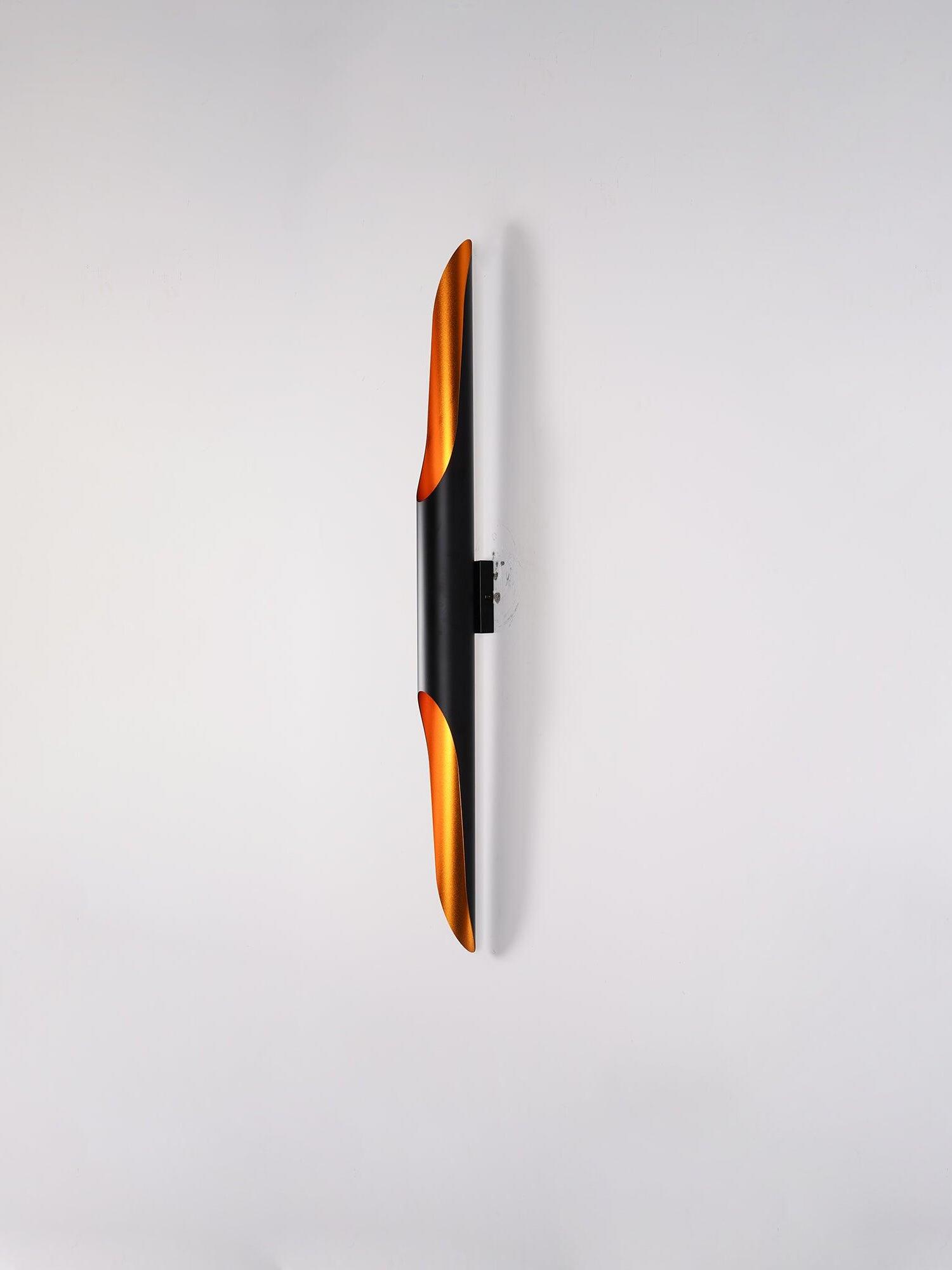 Side view of a black tube on a rectangular mounting plate with small surrounding marks on a white wall