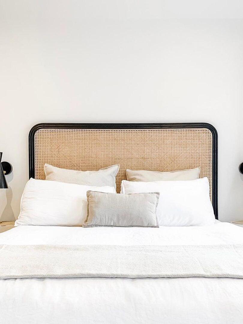 Wide bed scene with dark wall fixtures partly visible