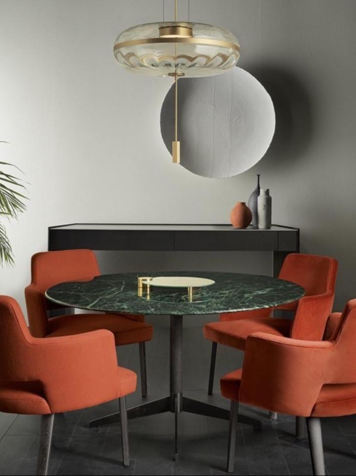 Jolie pendant above a table and red chairs