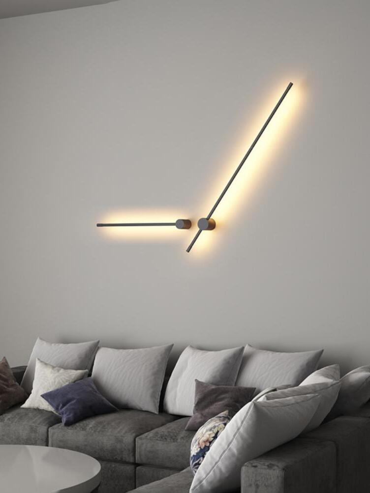 Angled linear light arrangement above a grey sofa