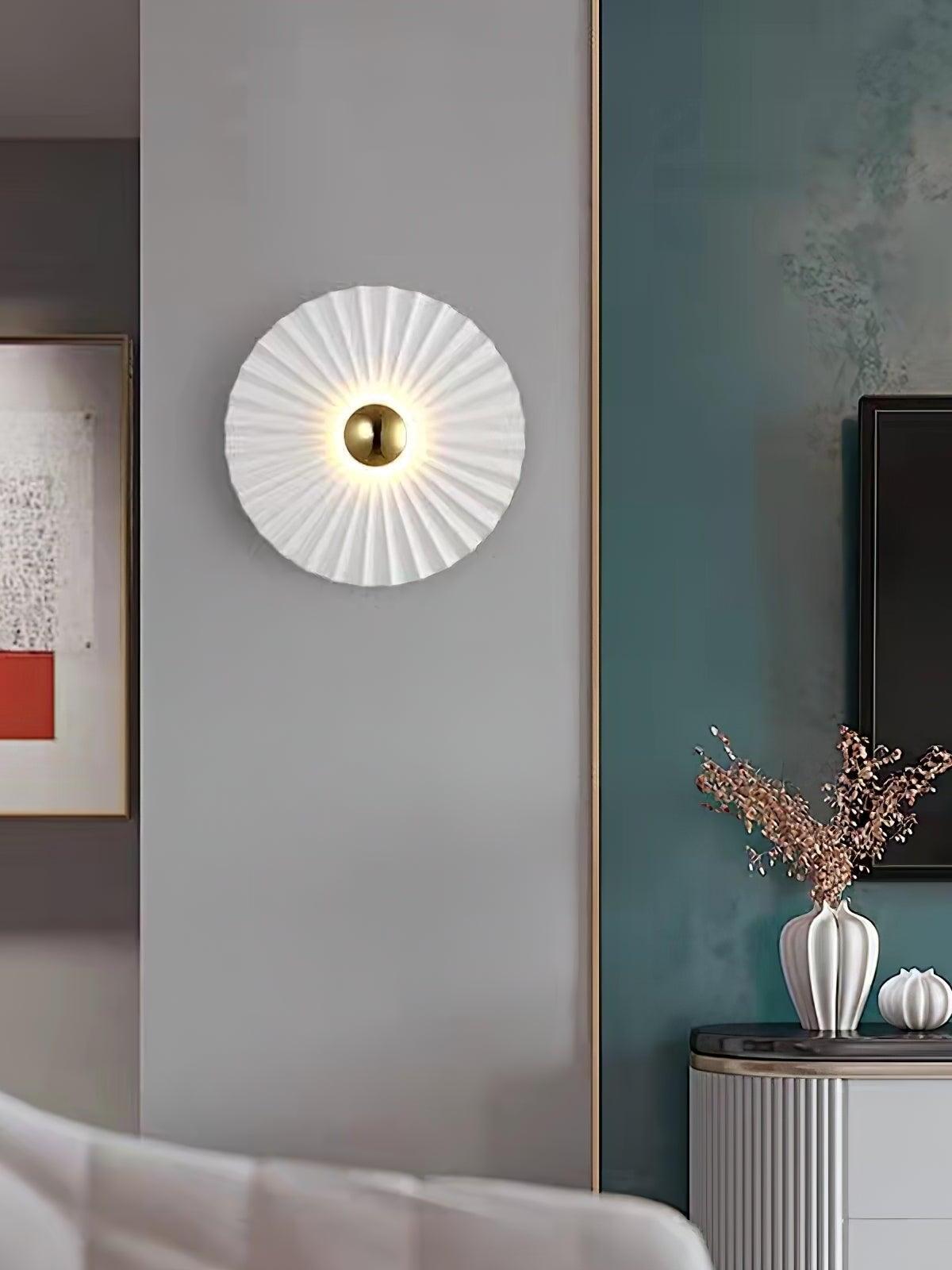 Single white pleated wall disc near teal wall