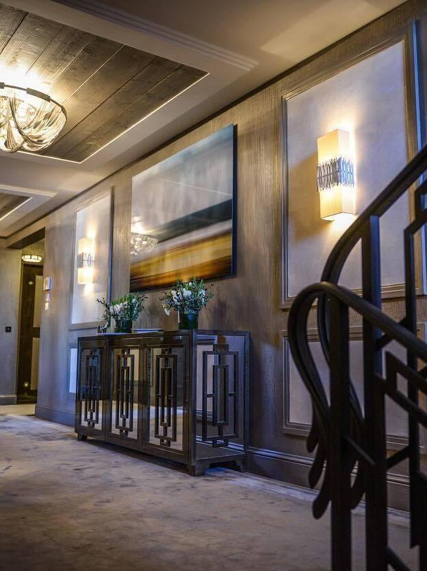 Silver chain ceiling fixture in corridor with wall lights