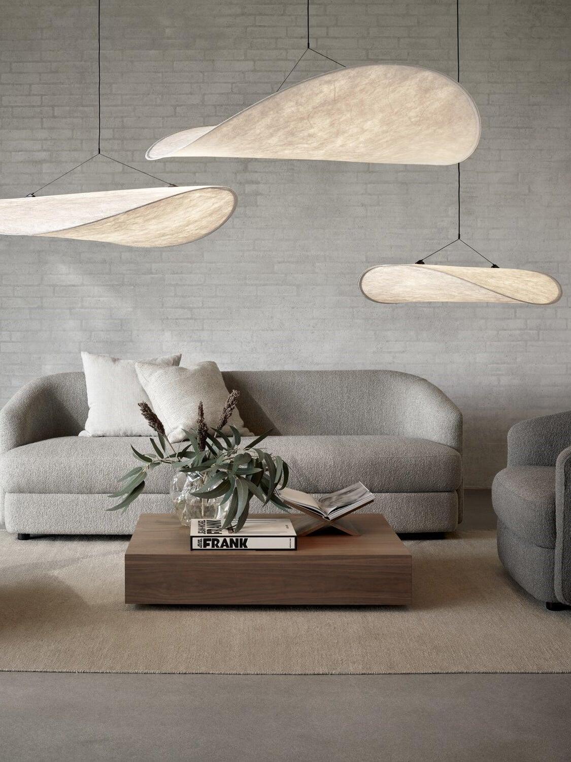 White sweeping shades at different heights over a sofa