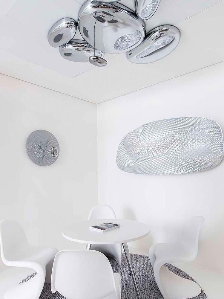 Reflective ceiling cluster above white dining table with separate pendant nearby