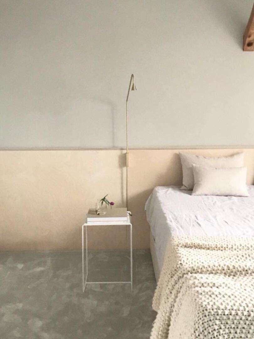 Golden wall sconce above bedside books