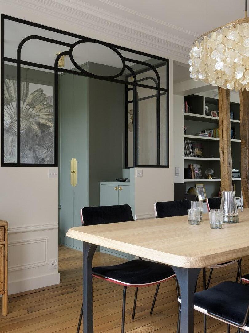 Shell chandelier above a table near a black-framed doorway