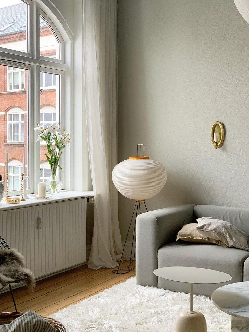 Round paper floor lamp by window and armchair