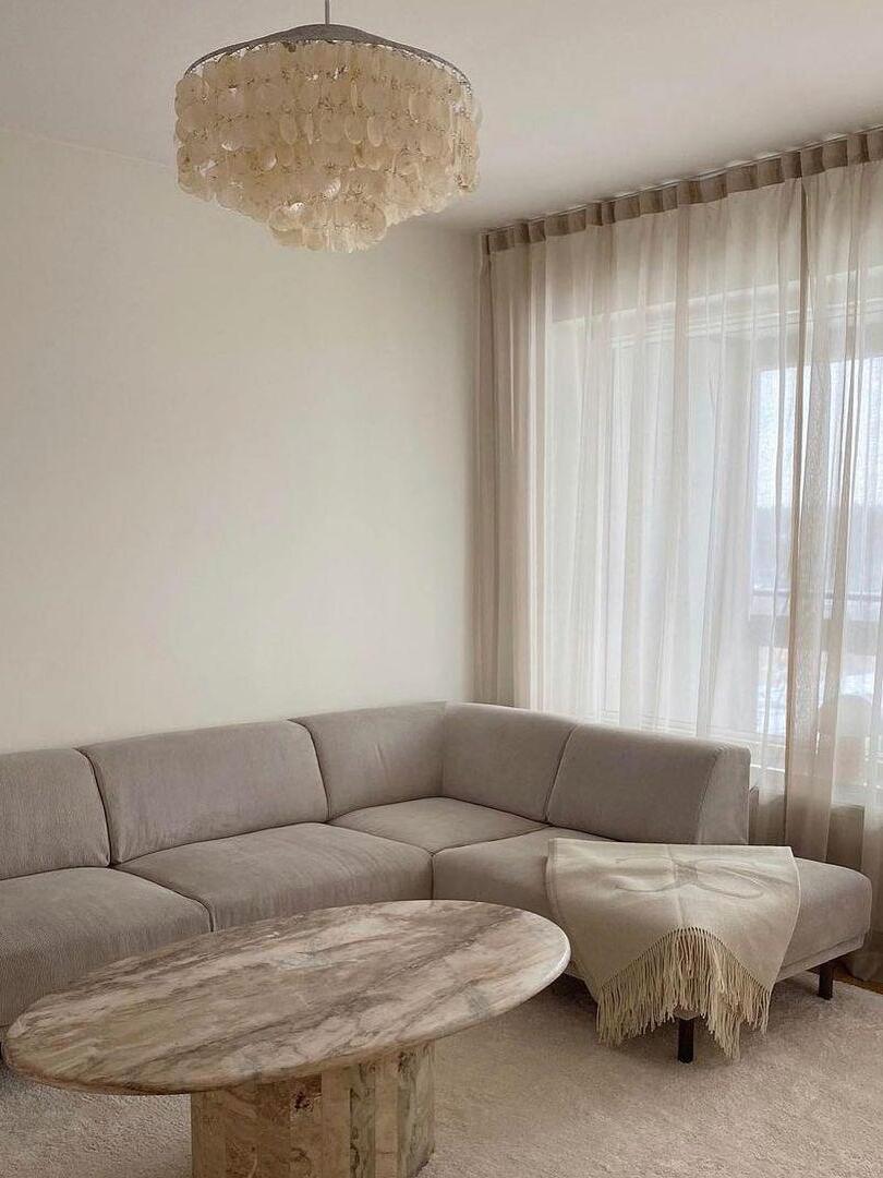 Round shell chandelier in a pale living room