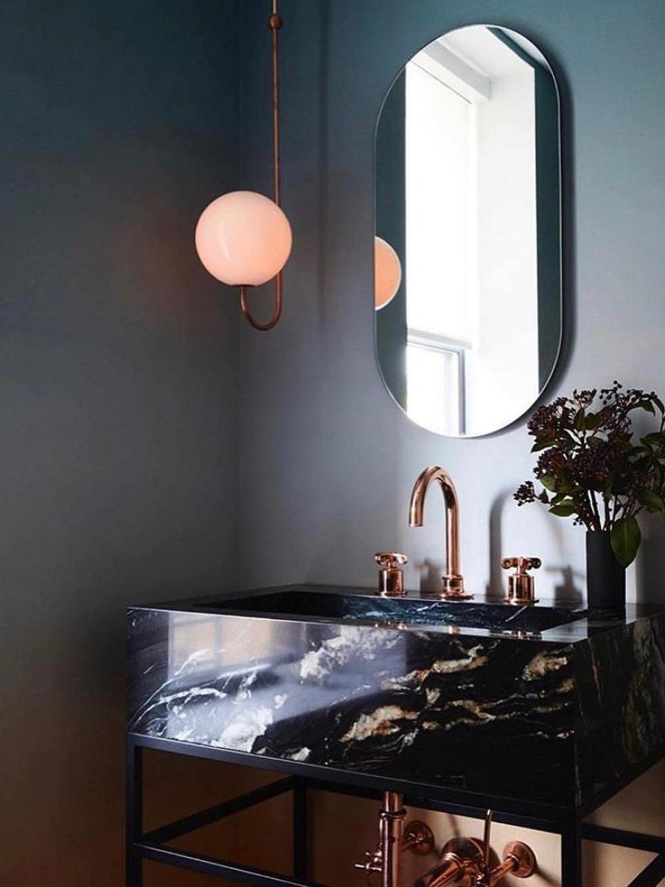 Single-globe pendant beside a bathroom mirror