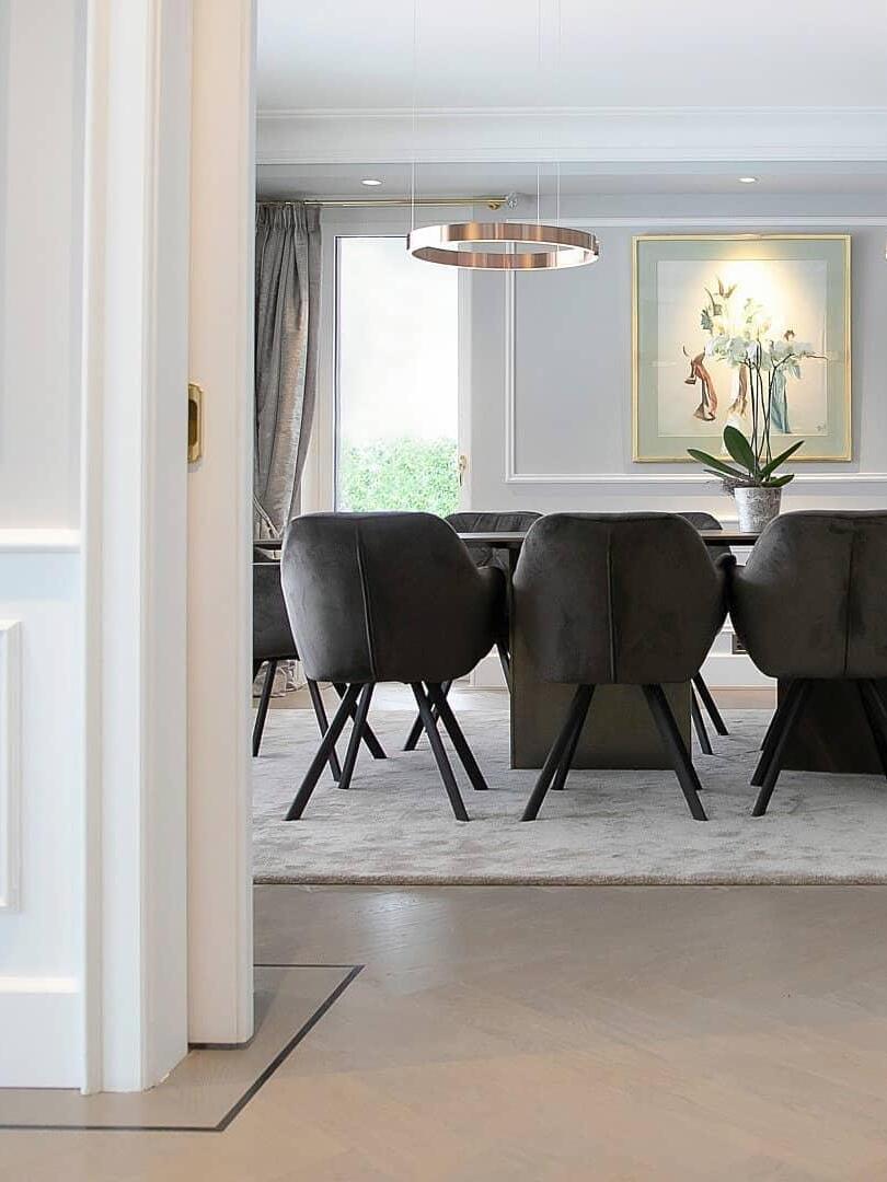Ring pendant above a dining table seen through a doorway