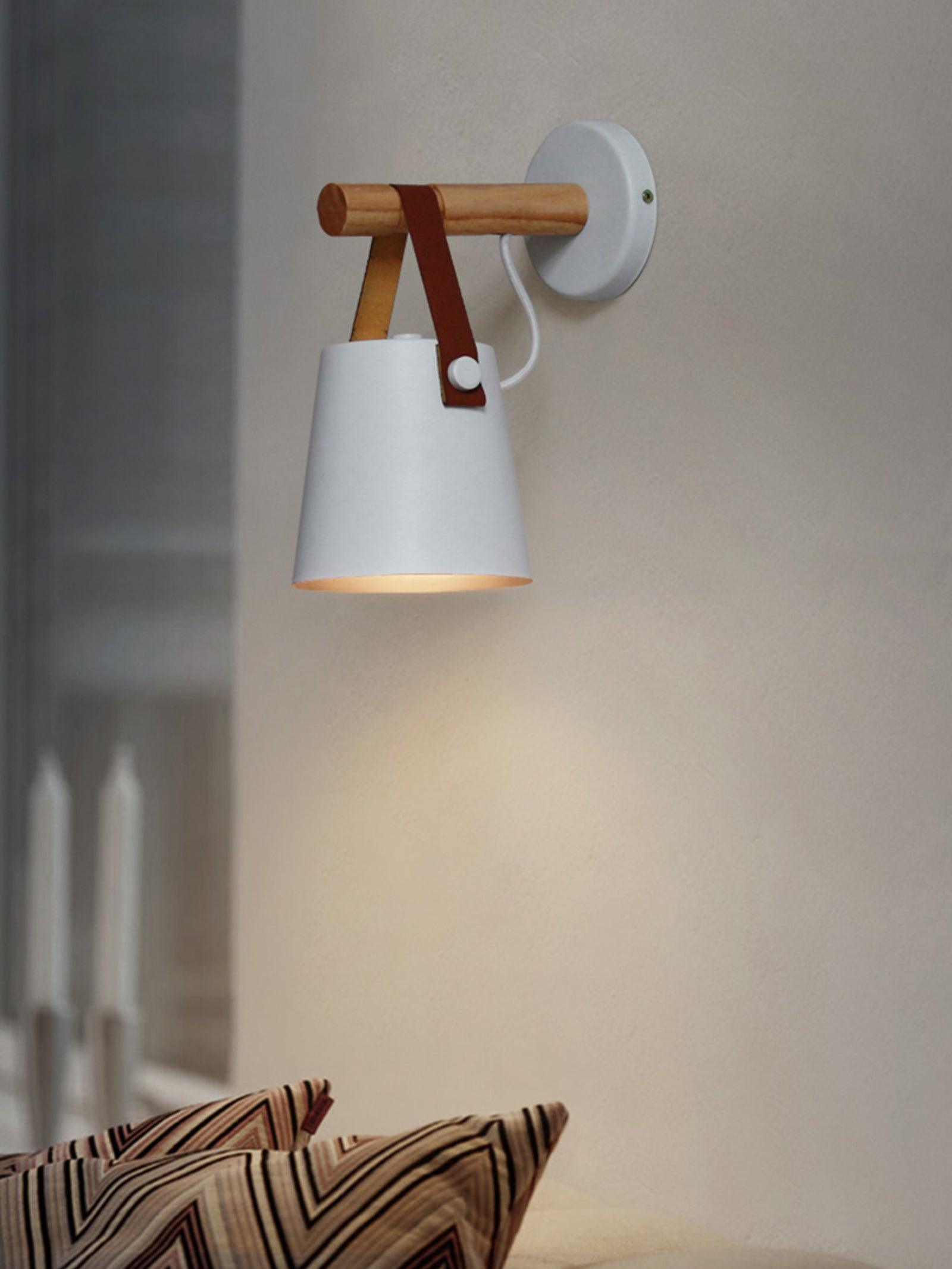 White wood-arm lamp above an upholstered headboard