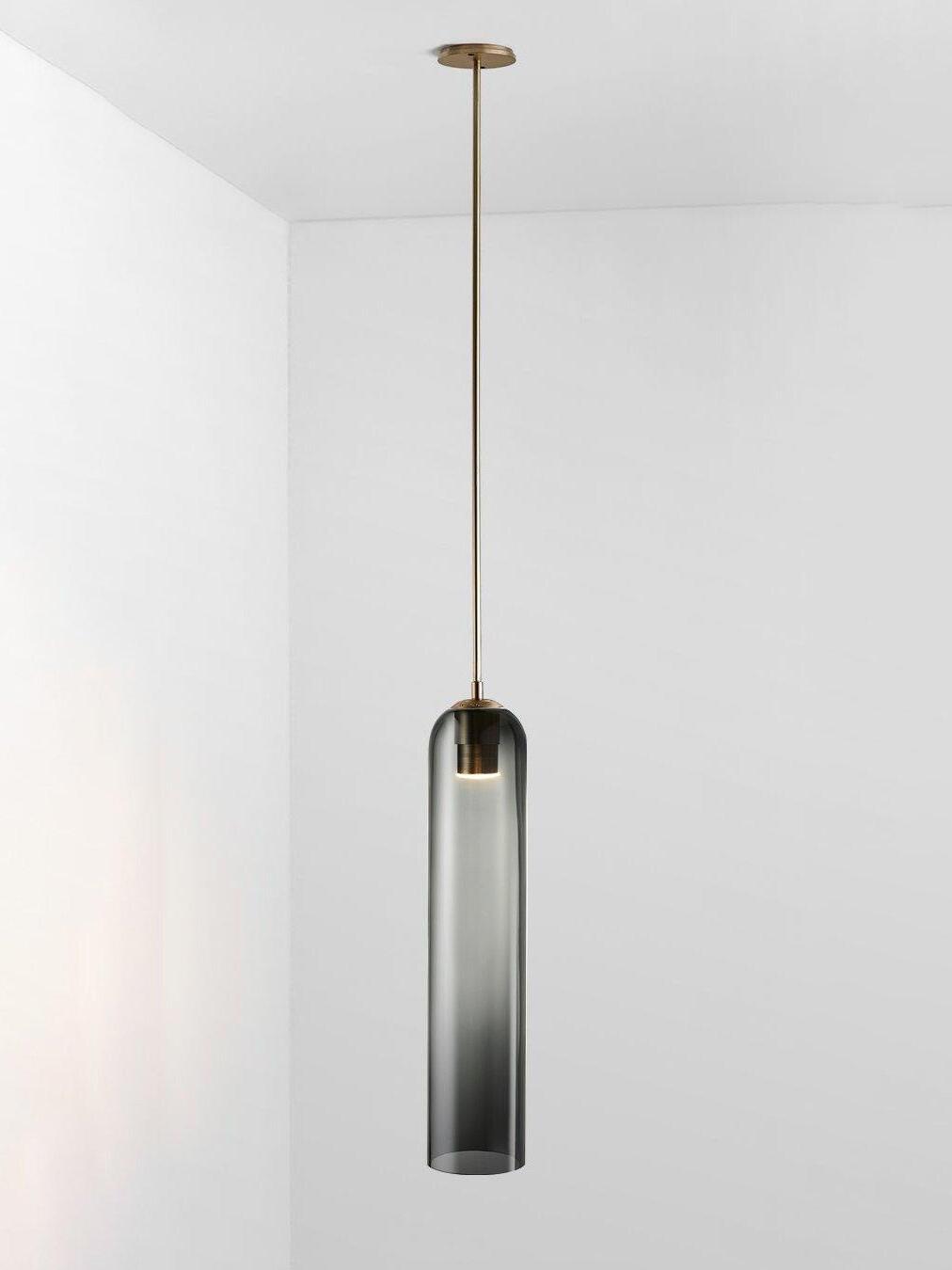 Spray gray glass Long Tube pendant with gold-toned rod and canopy, with socket and light visible through the smoky shade
