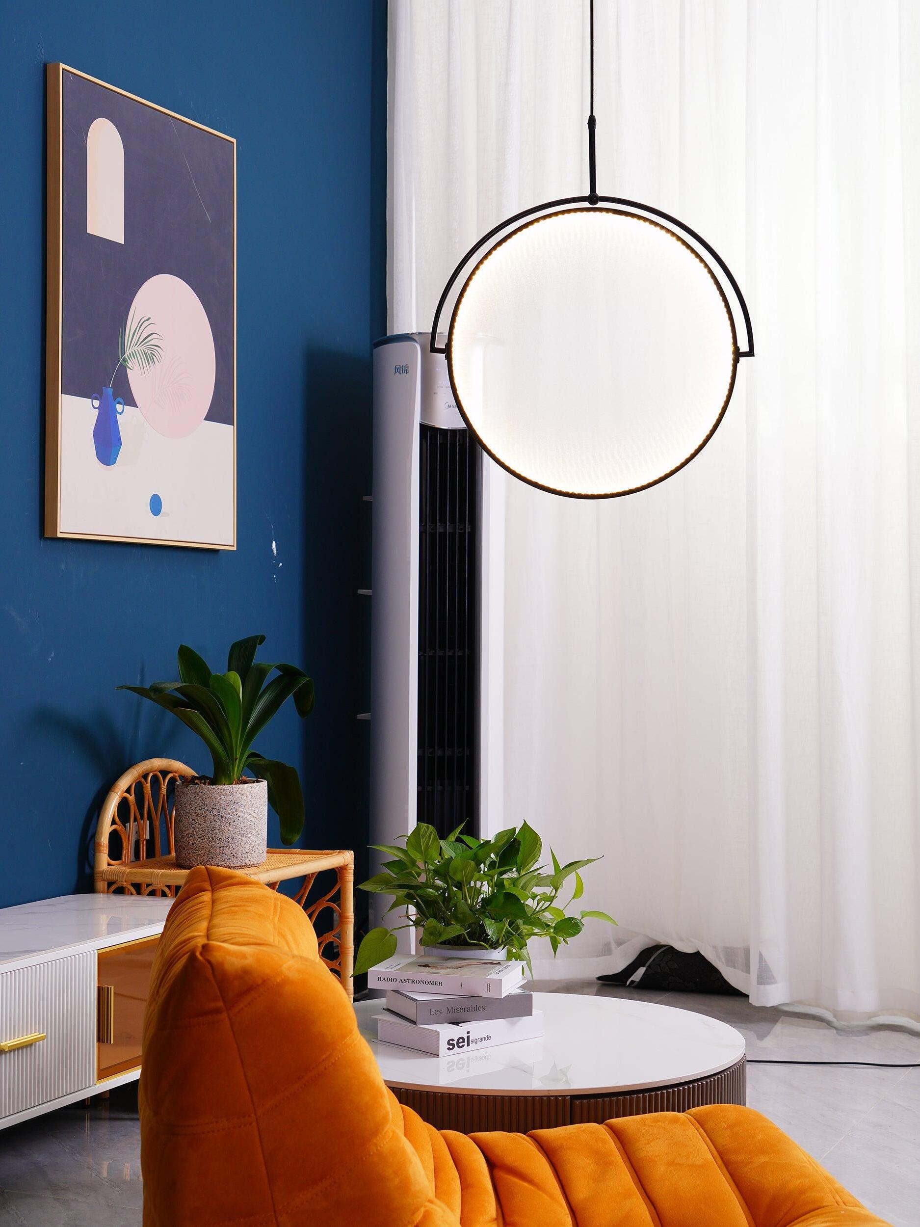 Vertical circular pendant near an orange chair