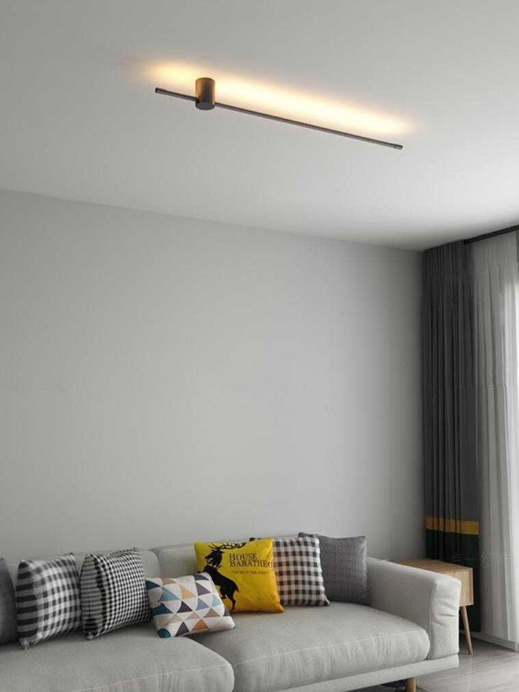 Ceiling-mounted linear light above a pale sofa