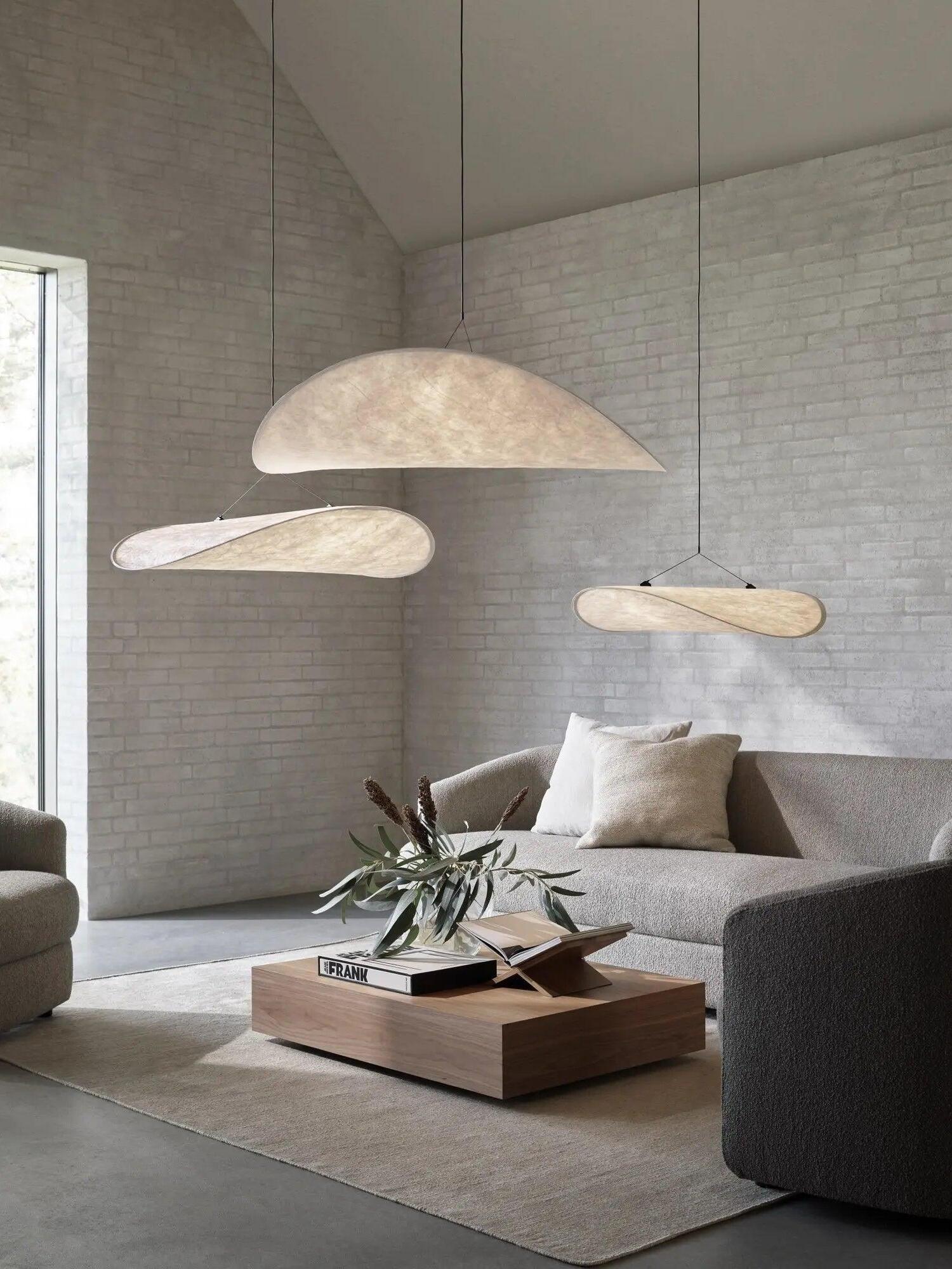 Several cloud-like pendants above a gray lounge