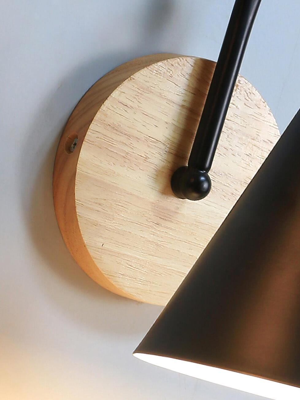 Close view of black cone shade and wooden wall plate