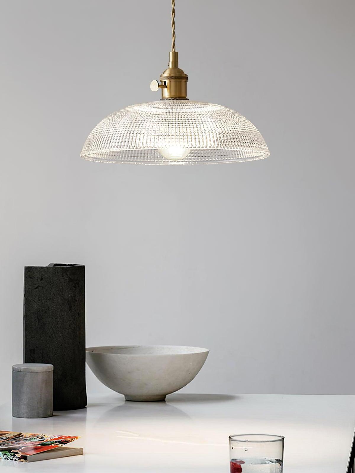 Shallow glass pendant above pale table surface