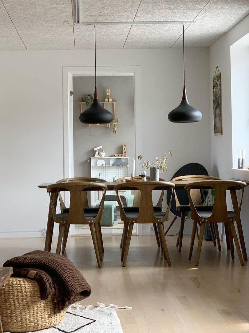 Two dark rounded pendants over a dining table