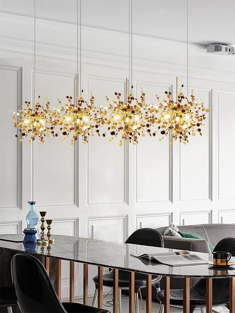 Long gold disc chandelier in front of white wall panelling