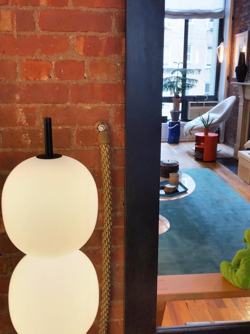 Upper glowing globes and black stem near brick wall