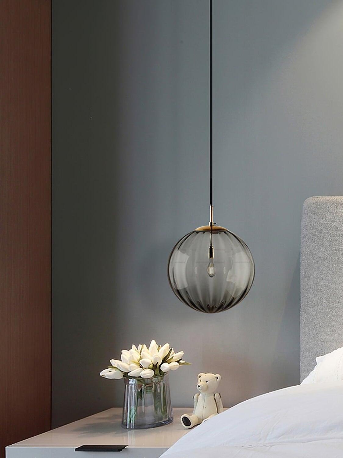 Smoke gray glass globe beside a bed