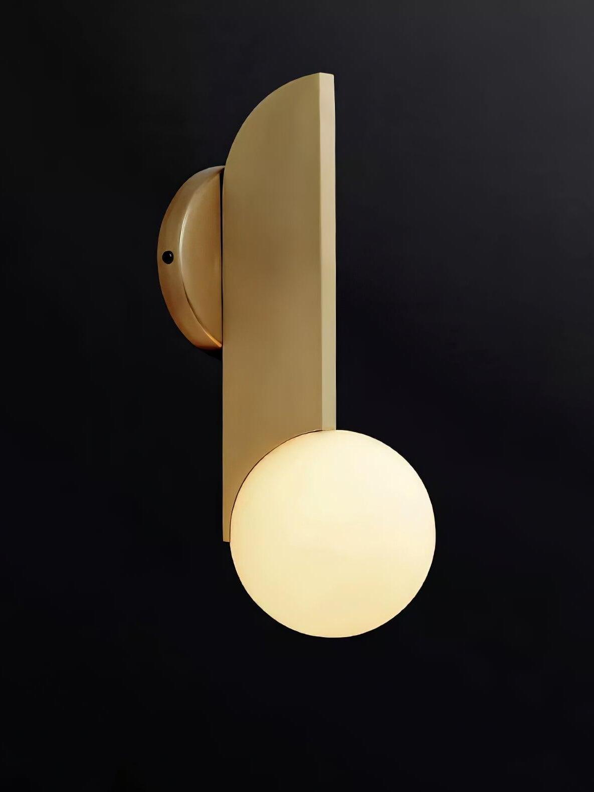 Globe-down wall light with illuminated sphere below an inverted gold-colour blade against black