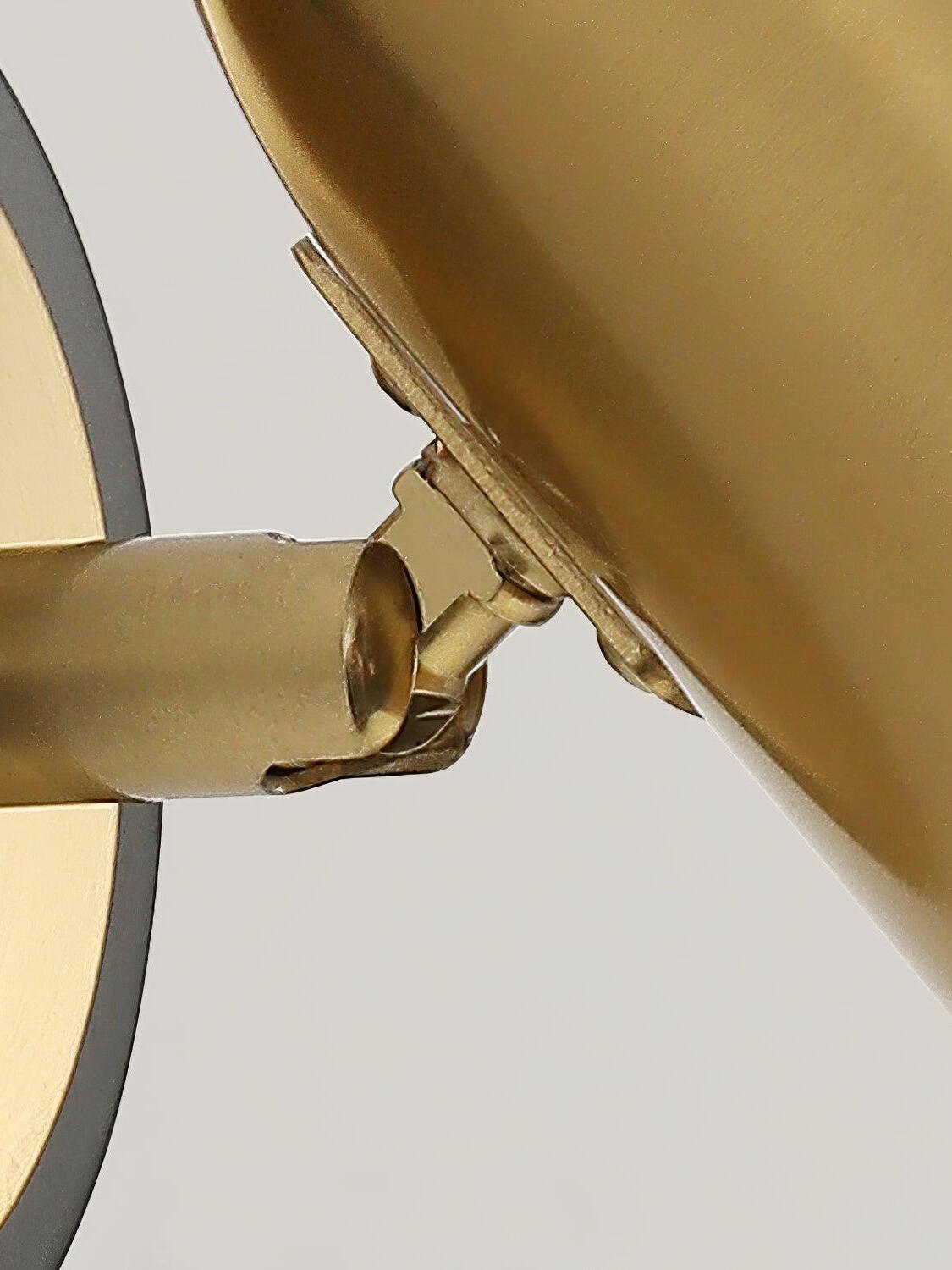 Close view of hinge behind gold wall-light shade