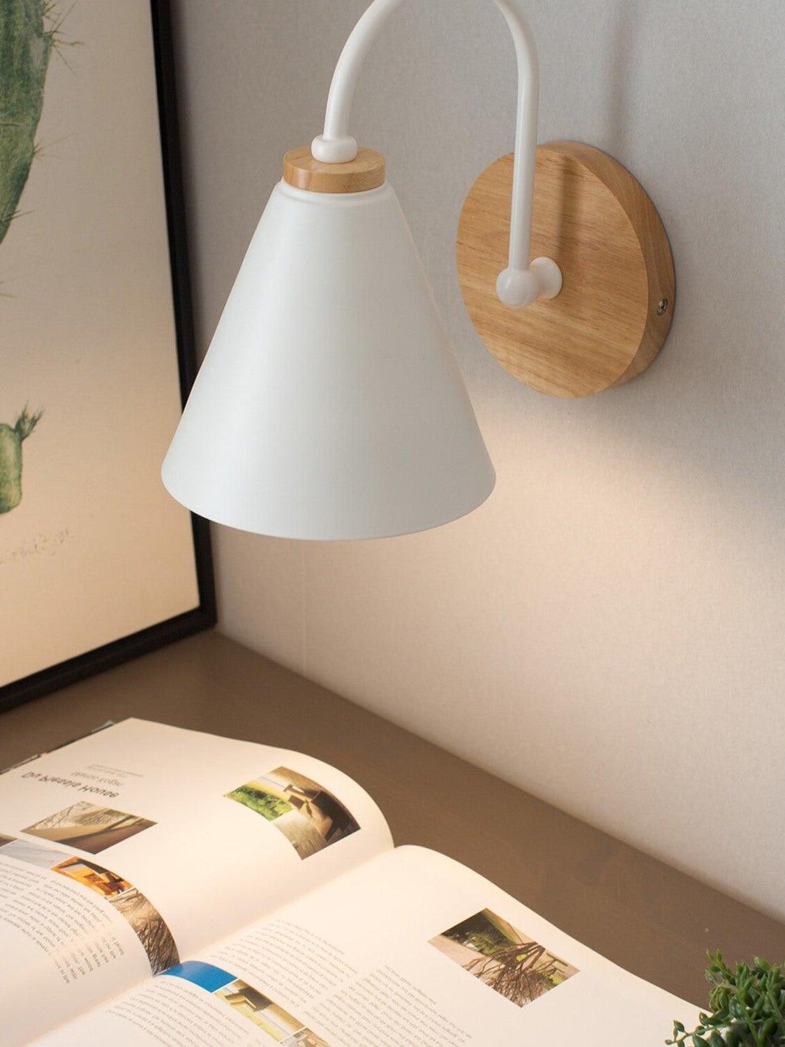 White wall lamp with wood plate above an open book