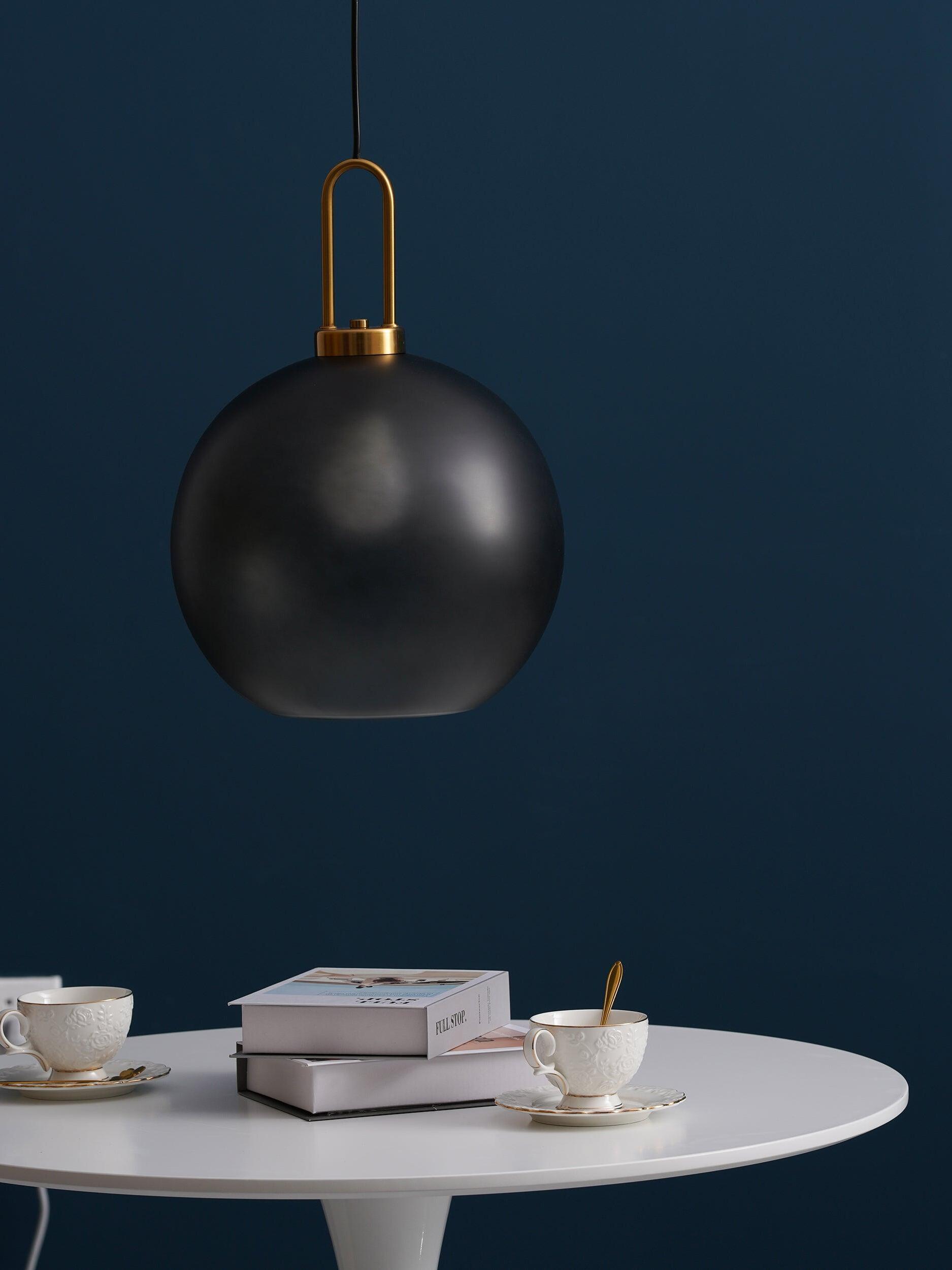 Dark glass globe above a round table against a blue wall