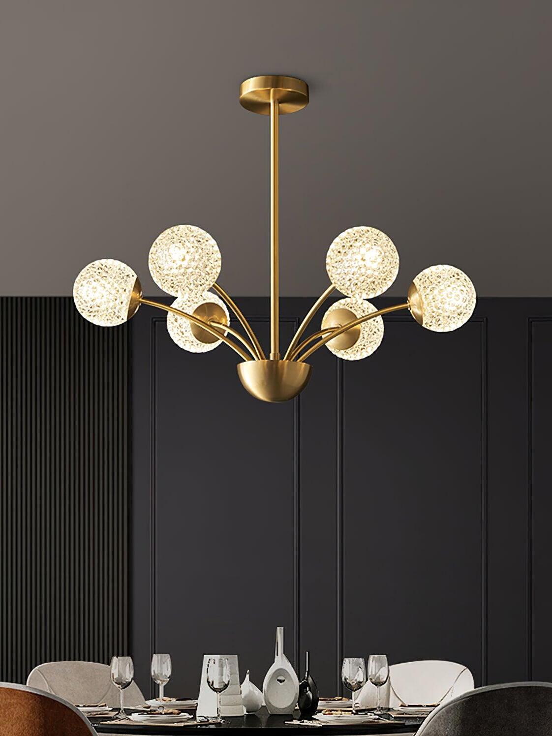 Six textured glowing globes on brass-tone arms above a round dining table with glasses and mixed chairs