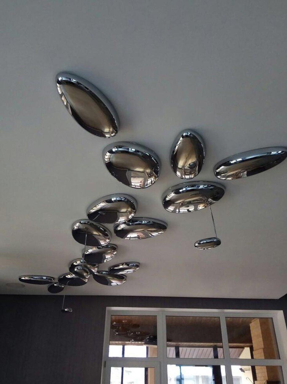 Long grouping of reflective ceiling modules with small suspended oval units