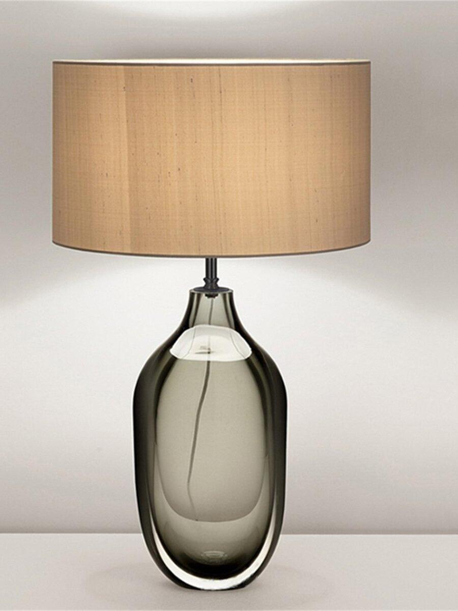 Smoky rounded-base lamp with beige shade on tabletop