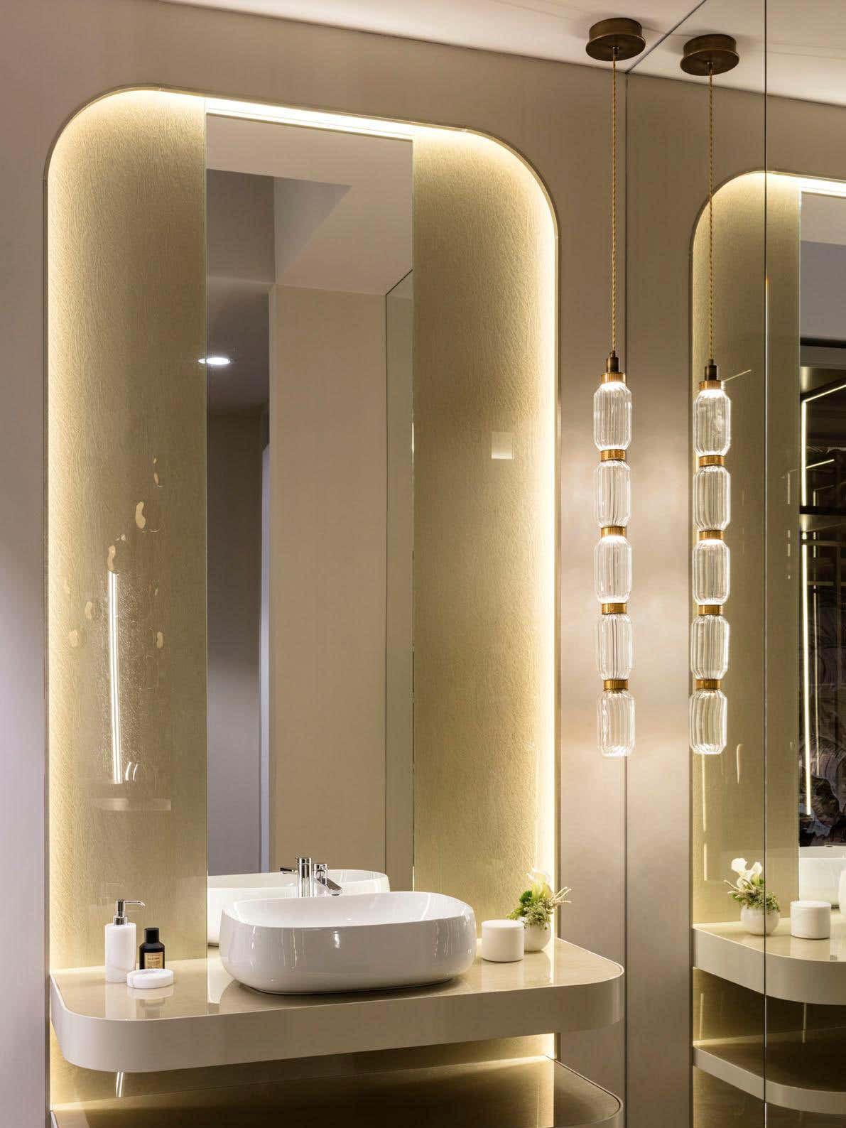 Three long clear glass pendants beside bathroom mirror
