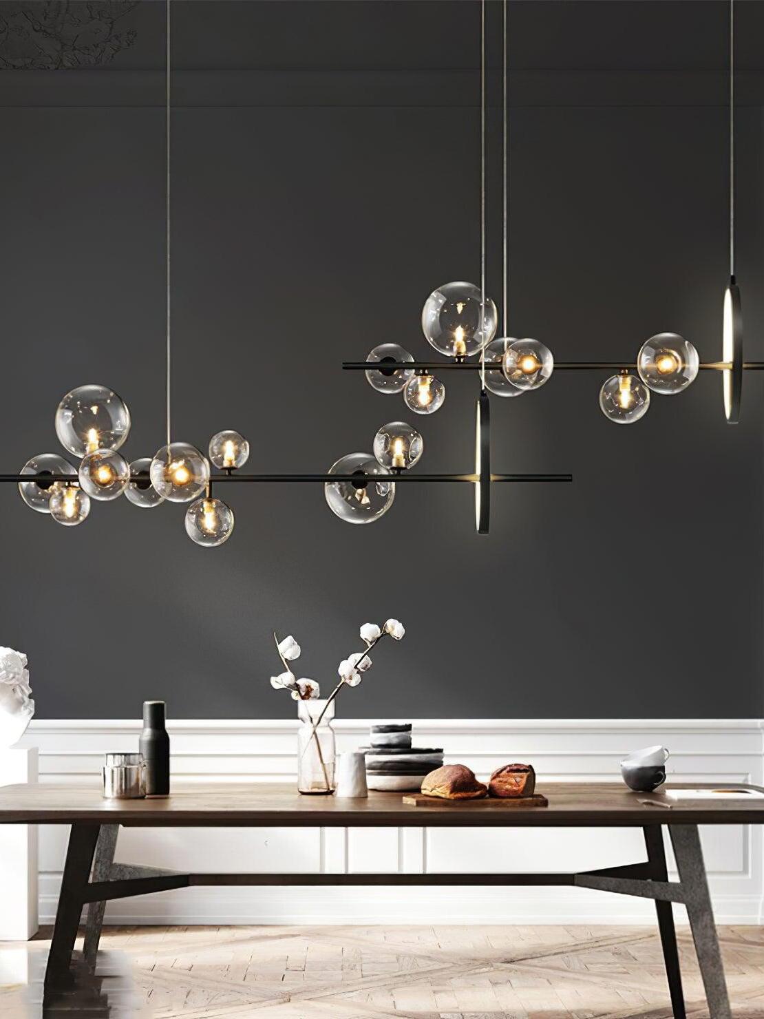 Two linear globe chandeliers above a dining space
