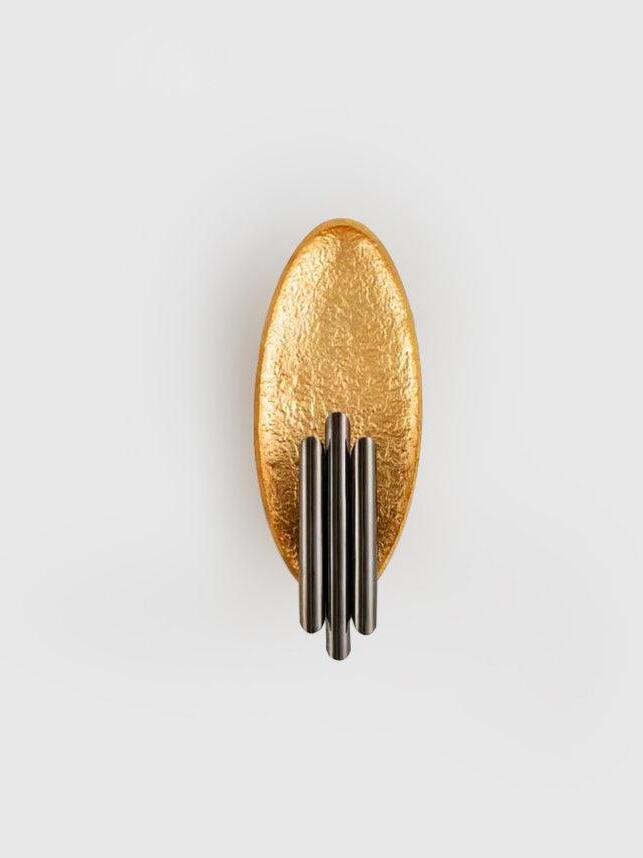 Unlit gold-tone oval and three staggered dark tube details