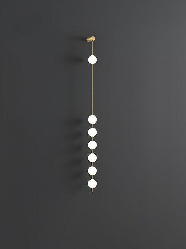 Seven-globe wall lamp with a long gap below the upper globe against dark grey