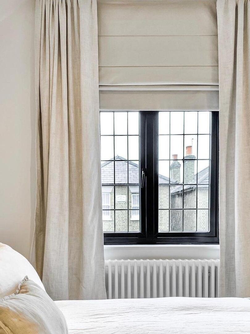 Bedroom window with pale curtains; light is outside the crop