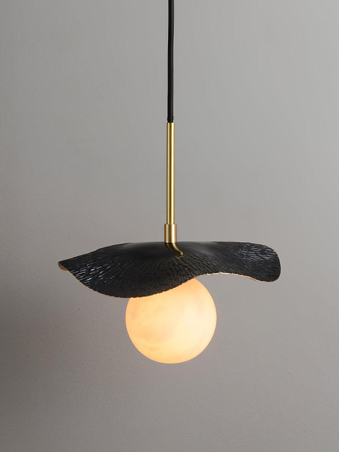 Side view of dark leaf shade and glowing globe