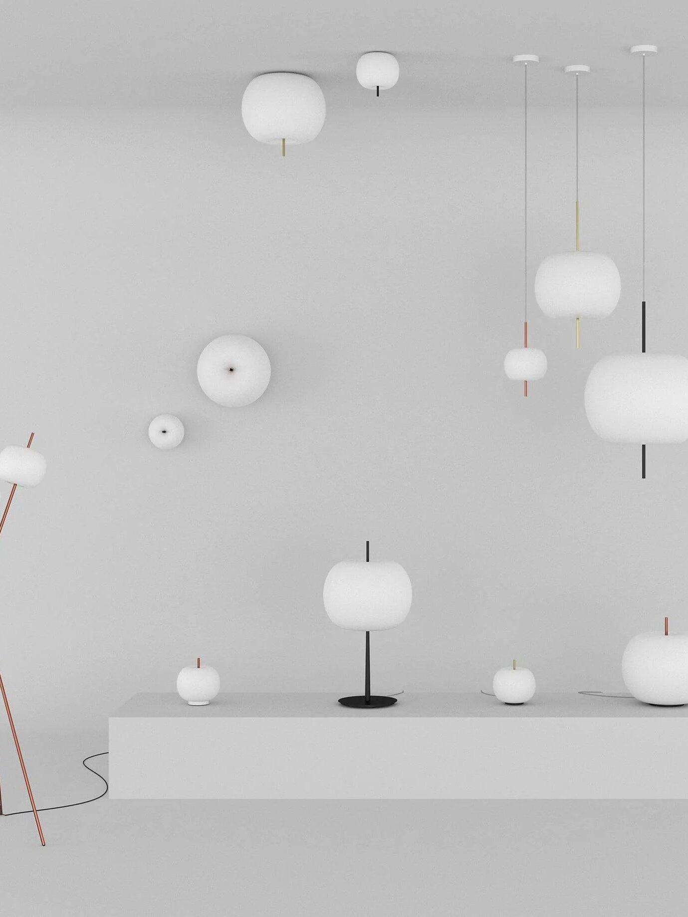 Display of rounded white lights in ceiling, hanging, wall and table arrangements with contrasting stems