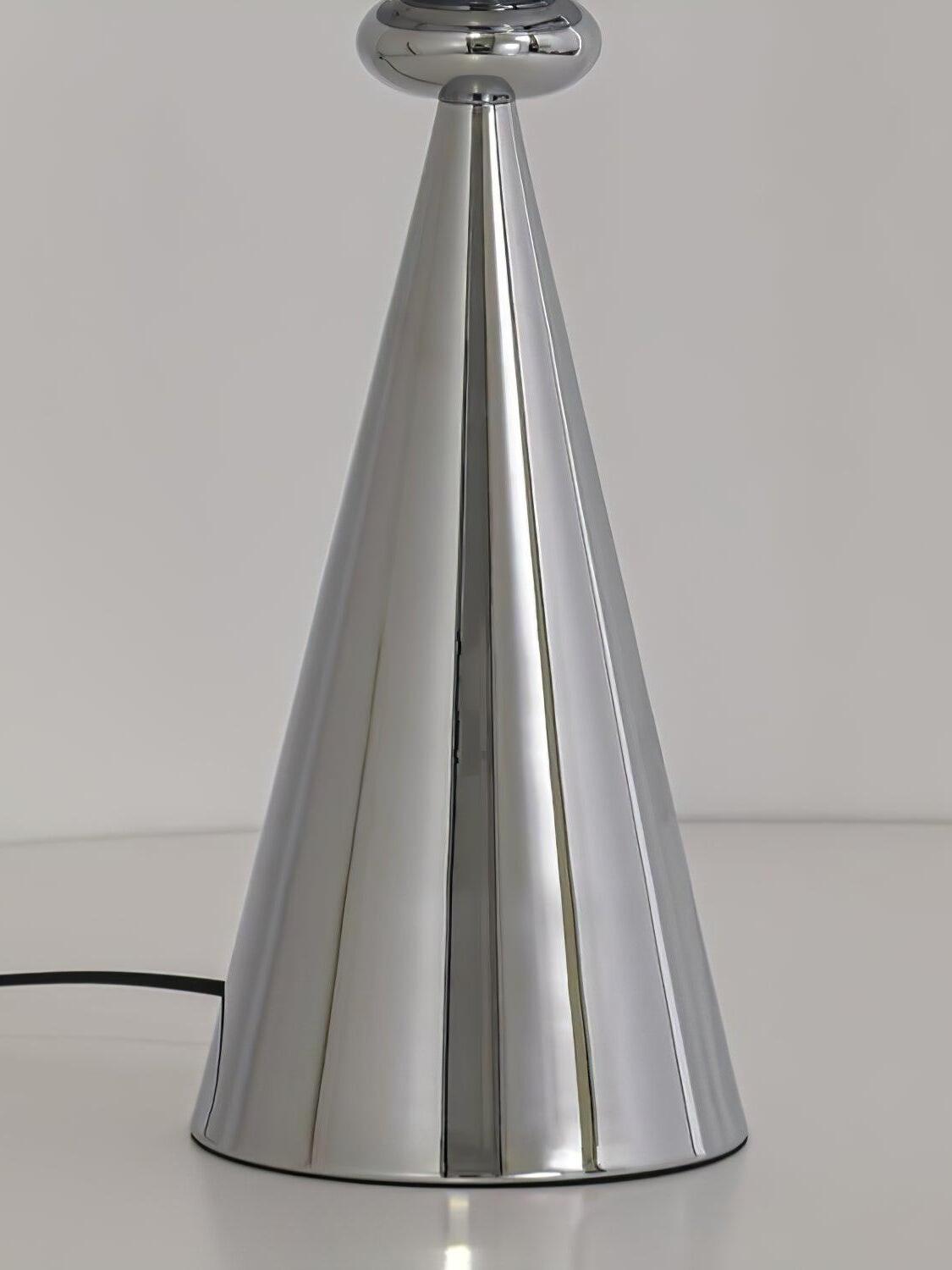 Close view of a reflective chrome cone base, rounded lamp neck and black cord
