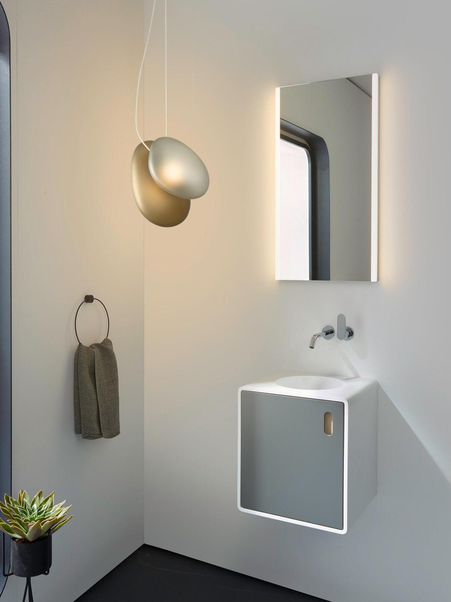 Blue-grey and amber pebble pendant near a wall mirror