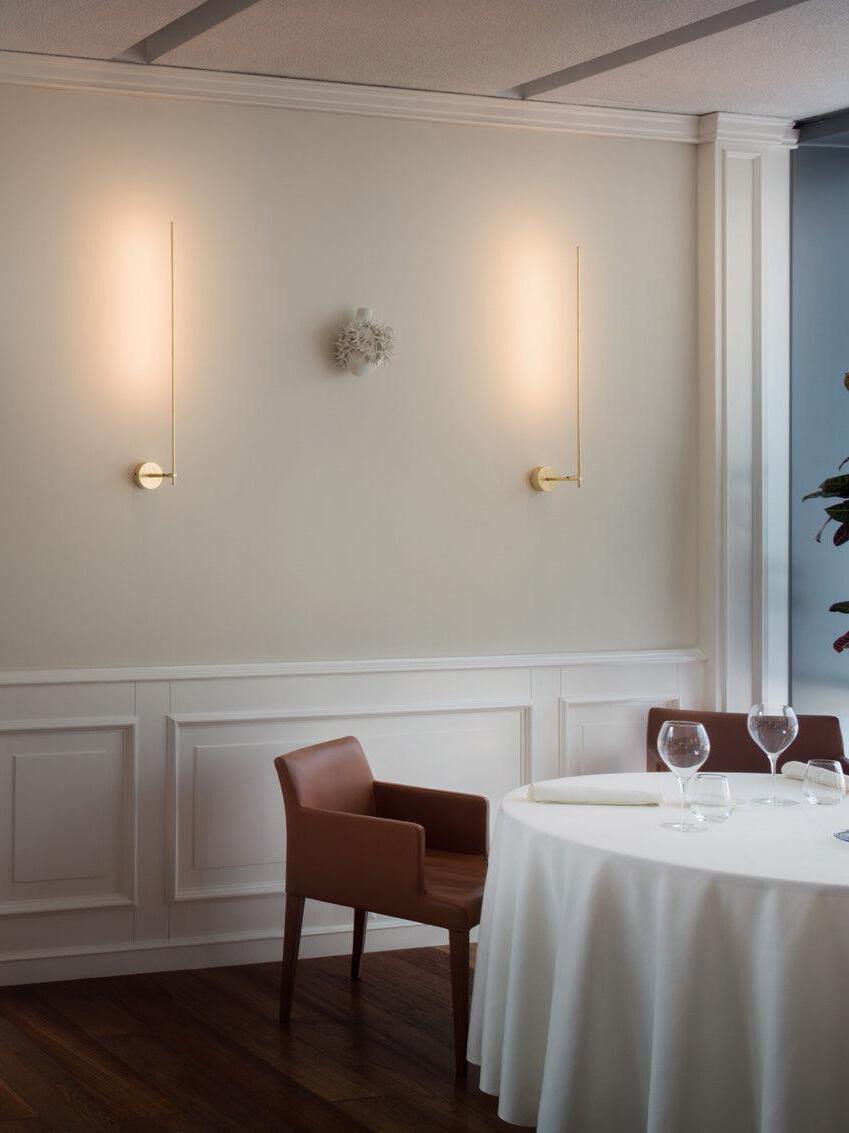 Paired linear wall accents above a dining table